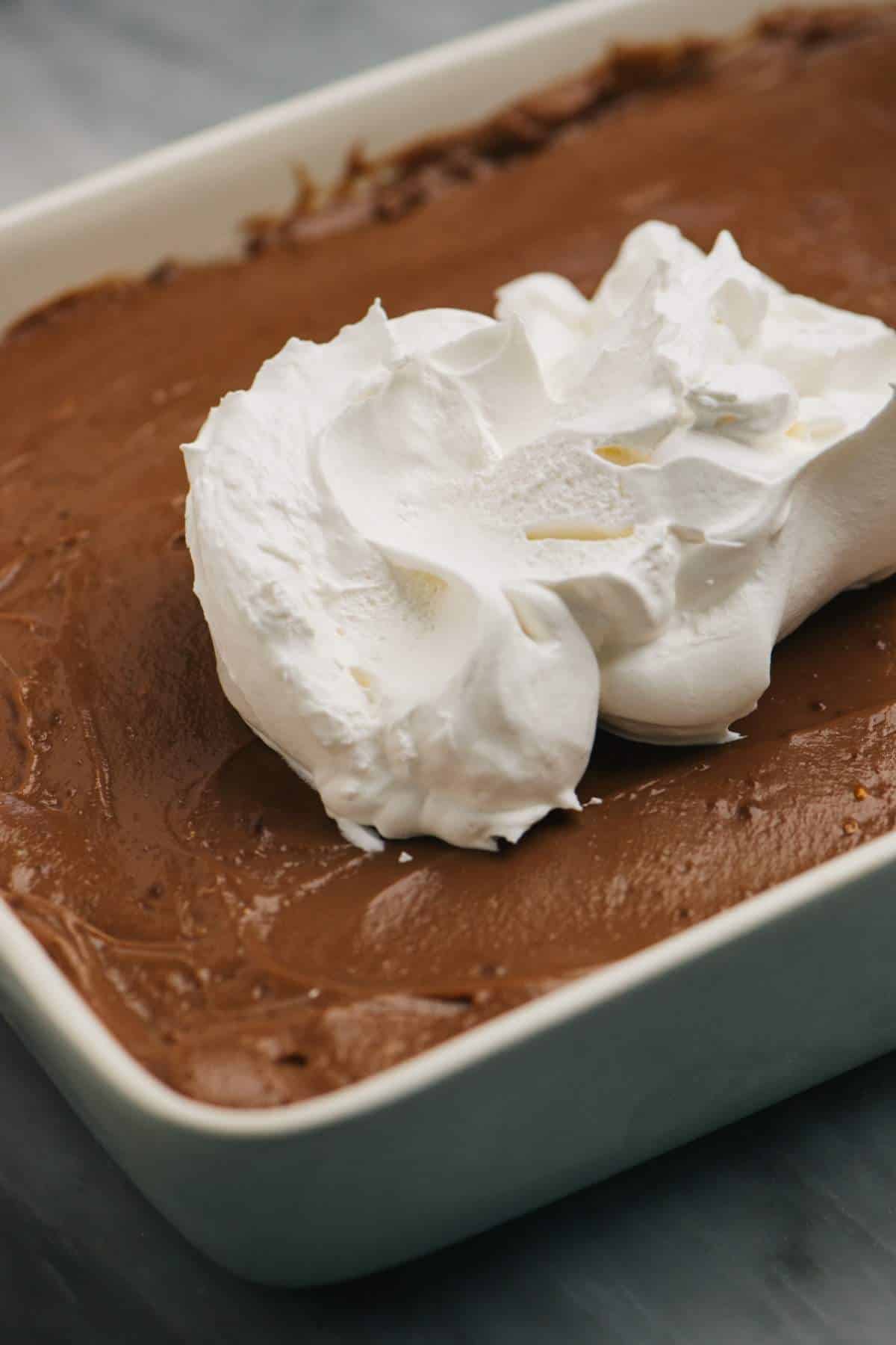 Spreading Cool Whip over chocolate pudding layer.