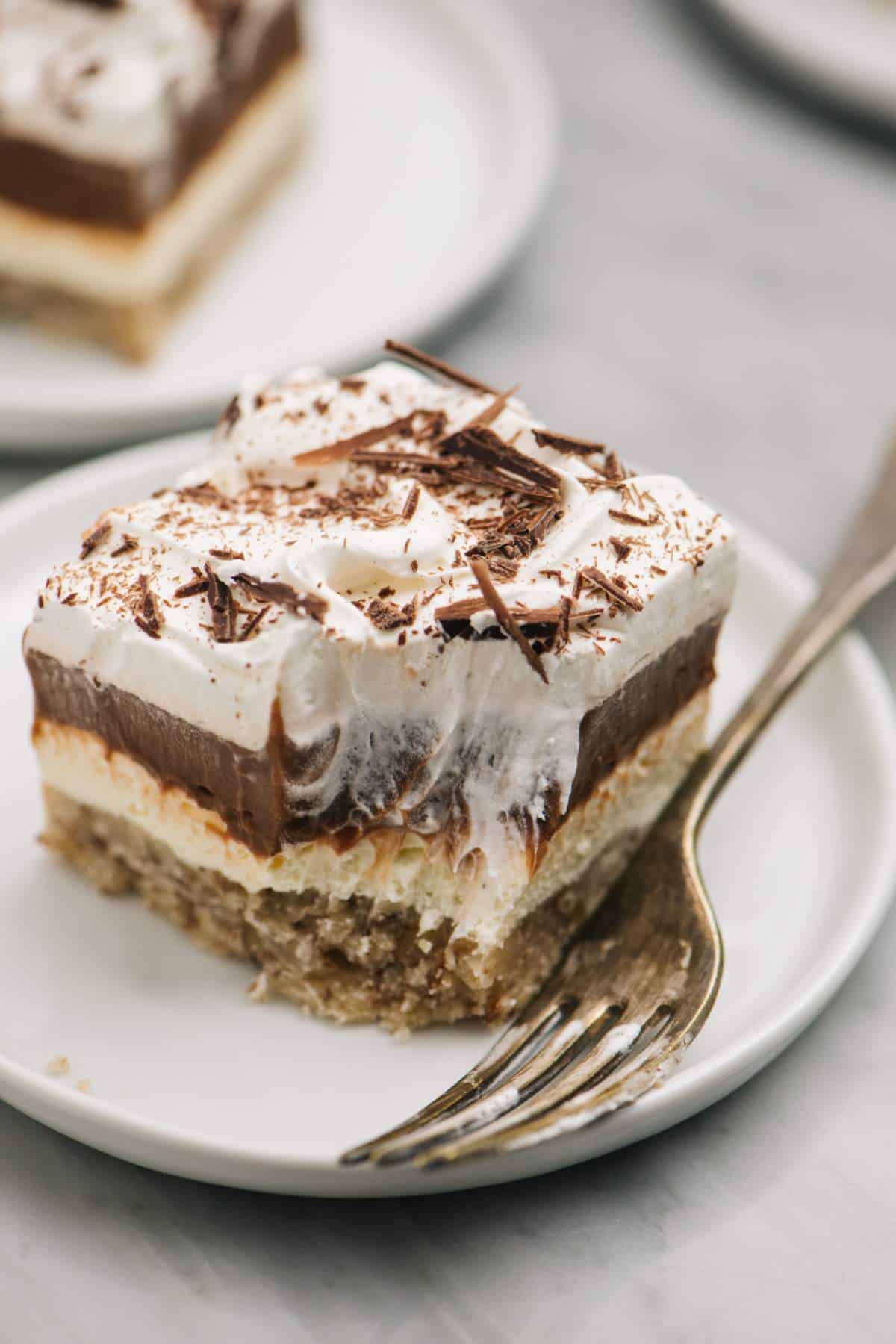 Chocolate delight layered dessert on a white plate with a fork.