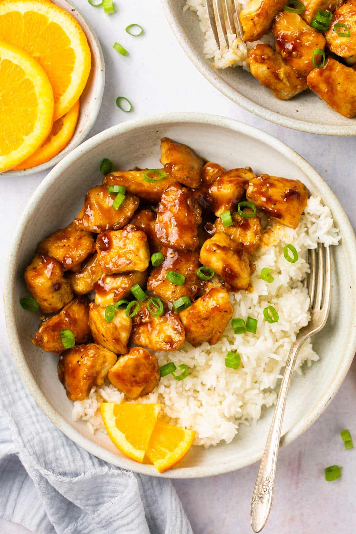 Saucy chicken with white rice and garnished with green onion.