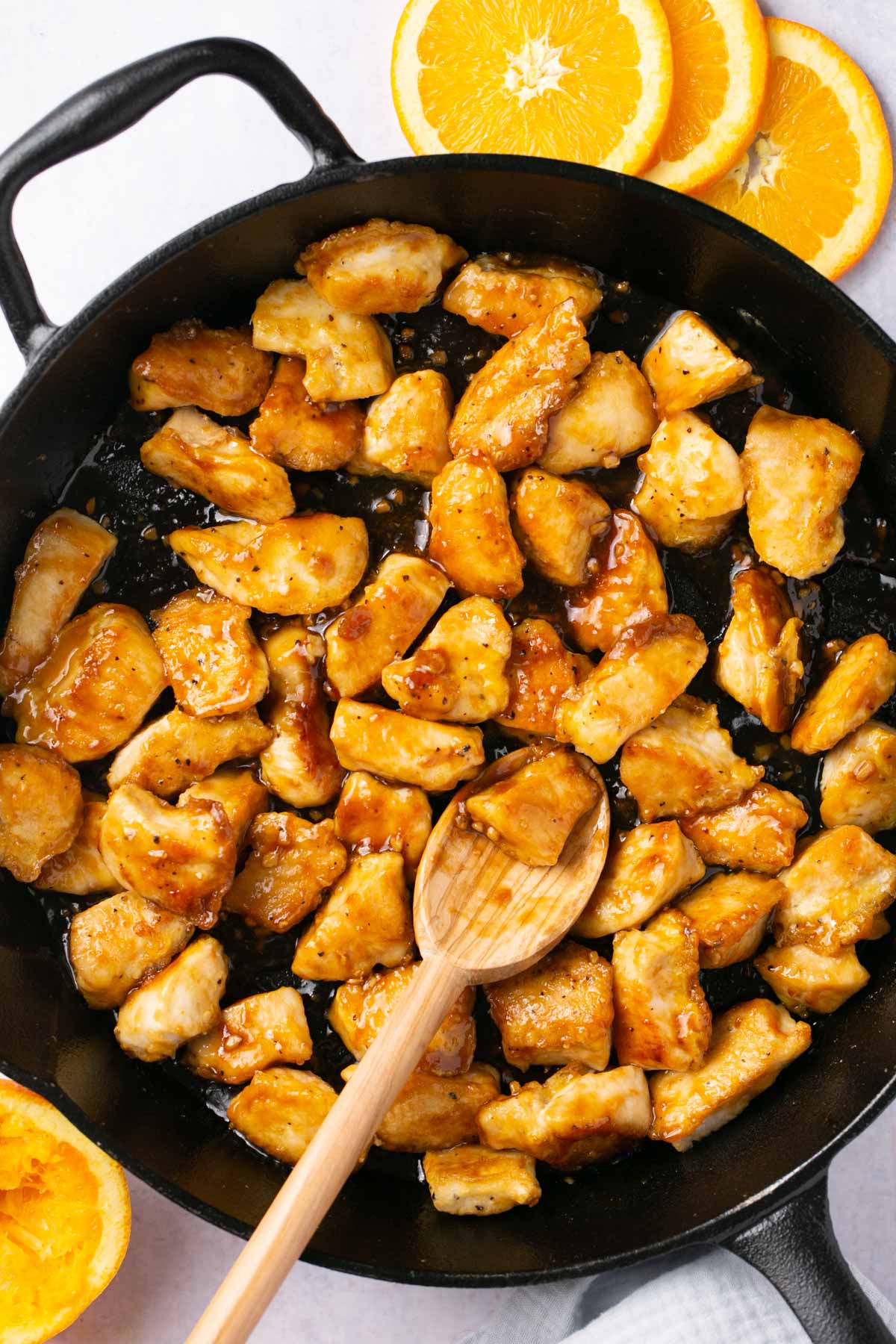 Cooking chicken and sauce in a large pan.