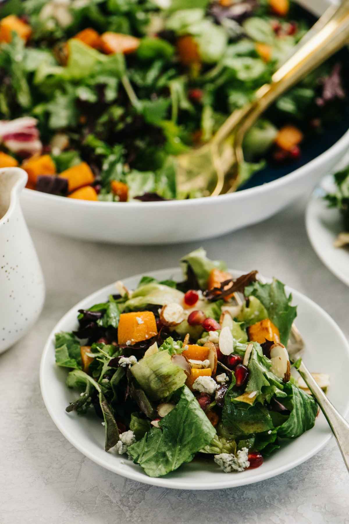 Butternut squash salad on a small white plate.