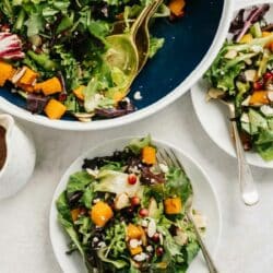 Thanksgiving salad topped with butternut squash, cheese and almonds.