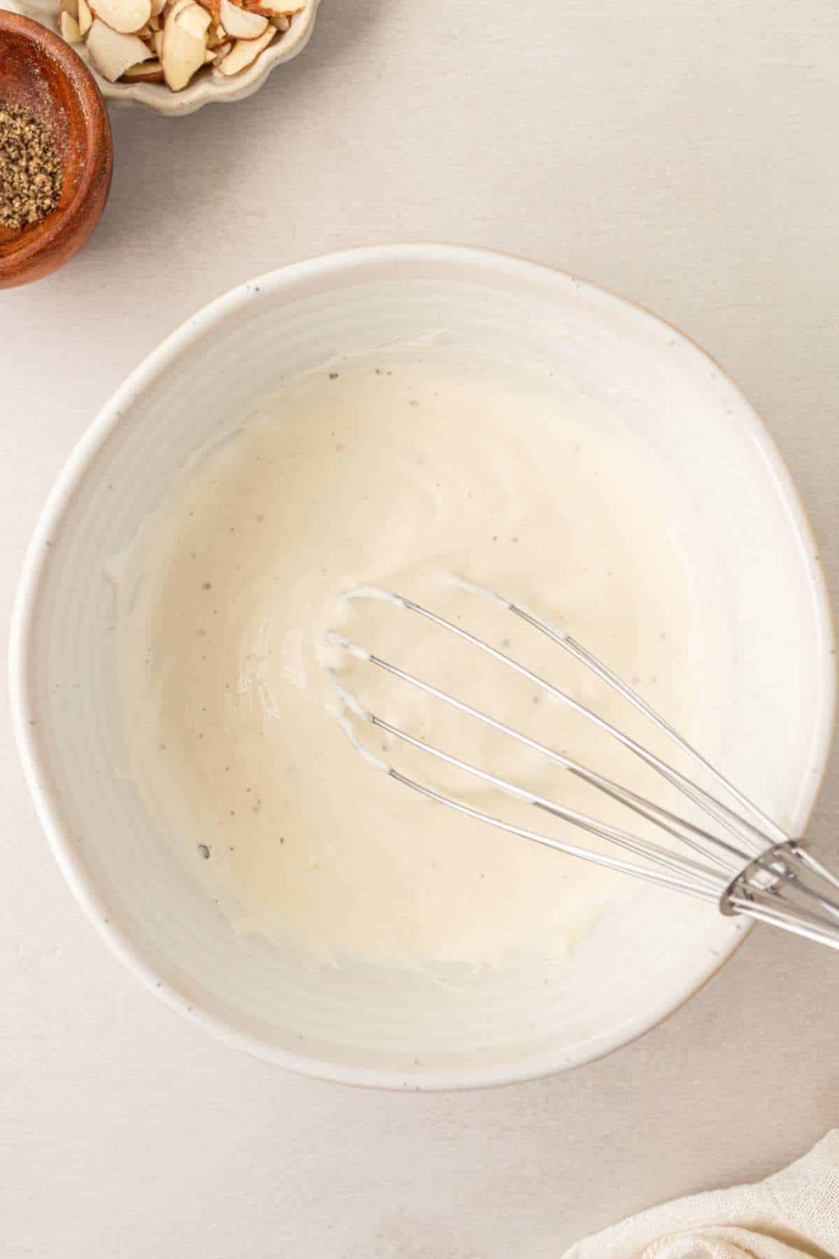 Whisking Greek yogurt and mayo in a small bowl.