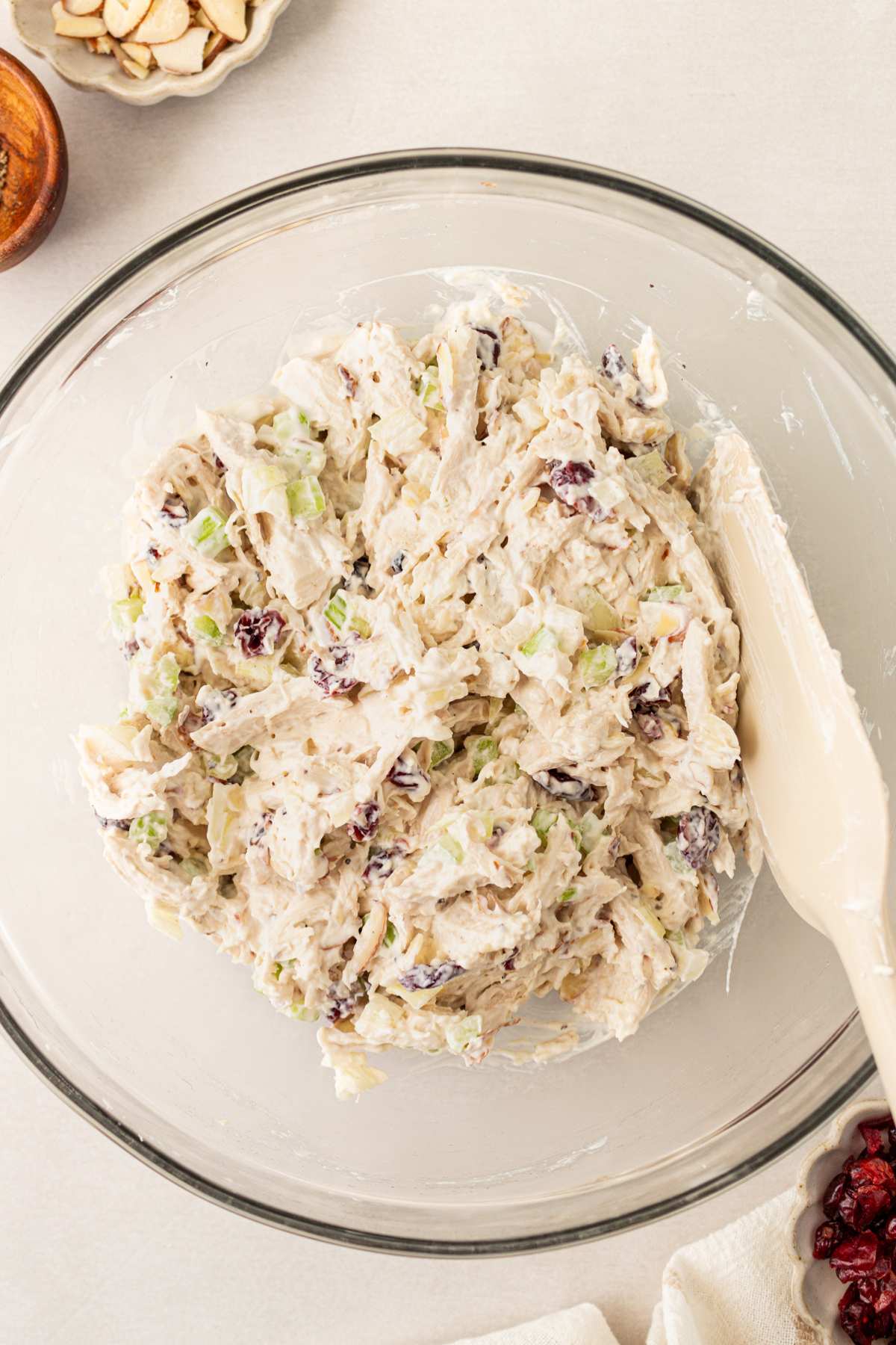 Stirring chicken salad in a bowl.