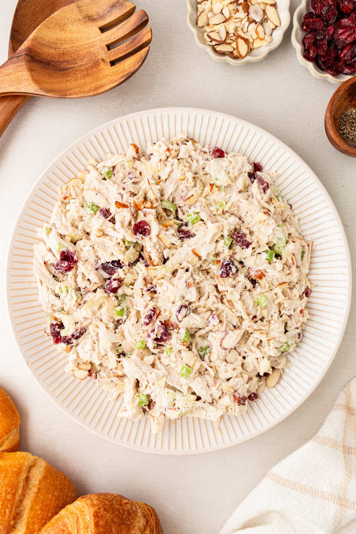 Healthy chicken salad in a white bowl near a wooden spoon.