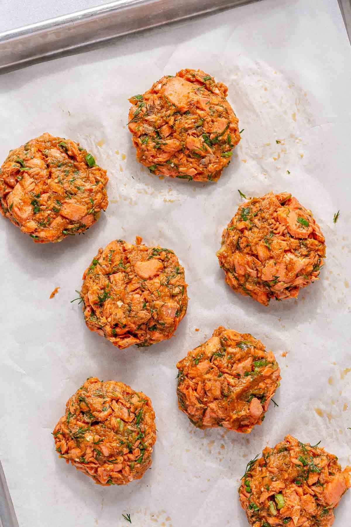 Formed salmon cakes on parchment paper.