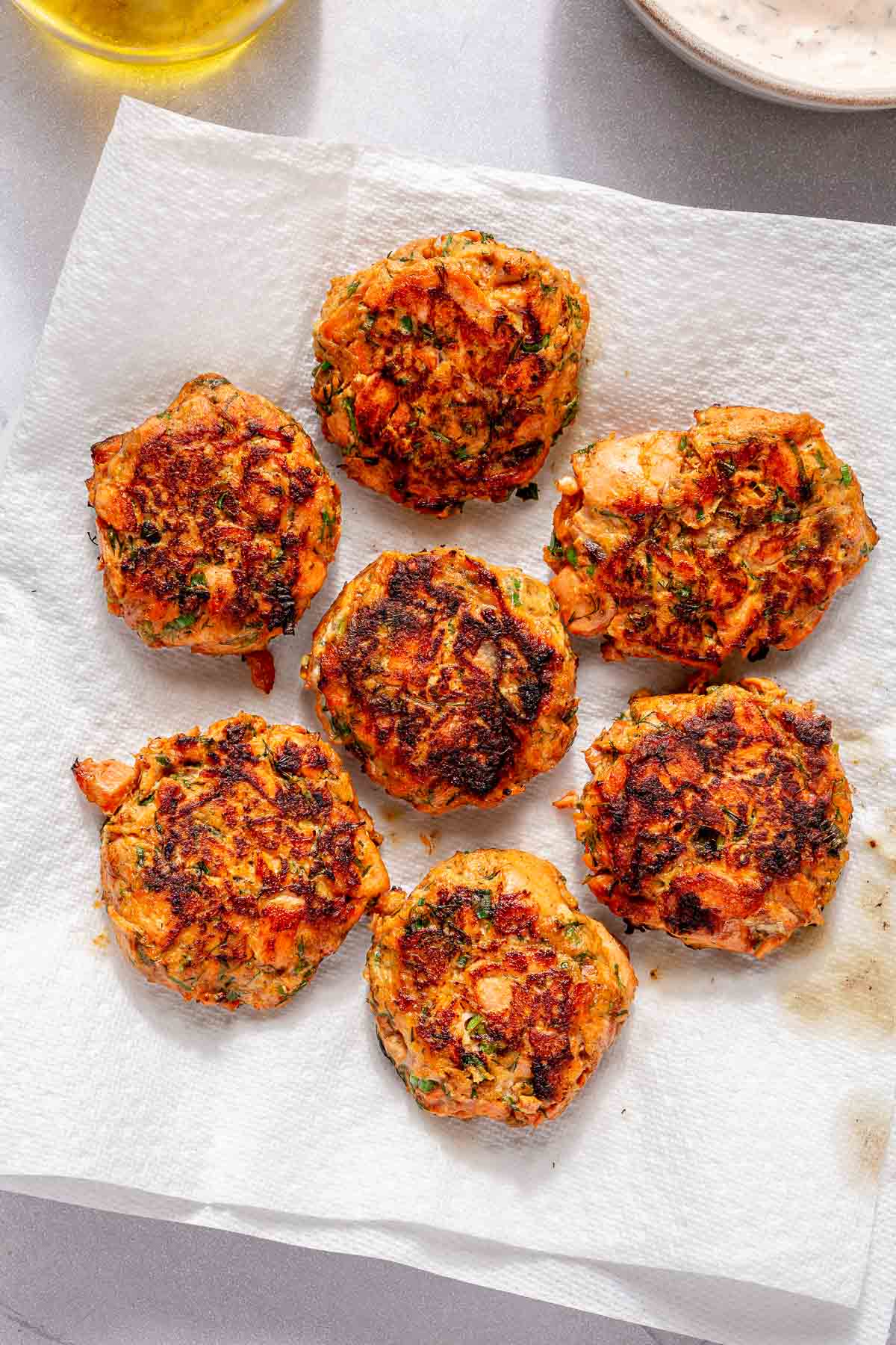 Cooked salmon patties on a plate lined with paper towels.