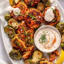 Sweet potato salmon cakes served with Brussels sprouts and a creamy sriracha sauce.