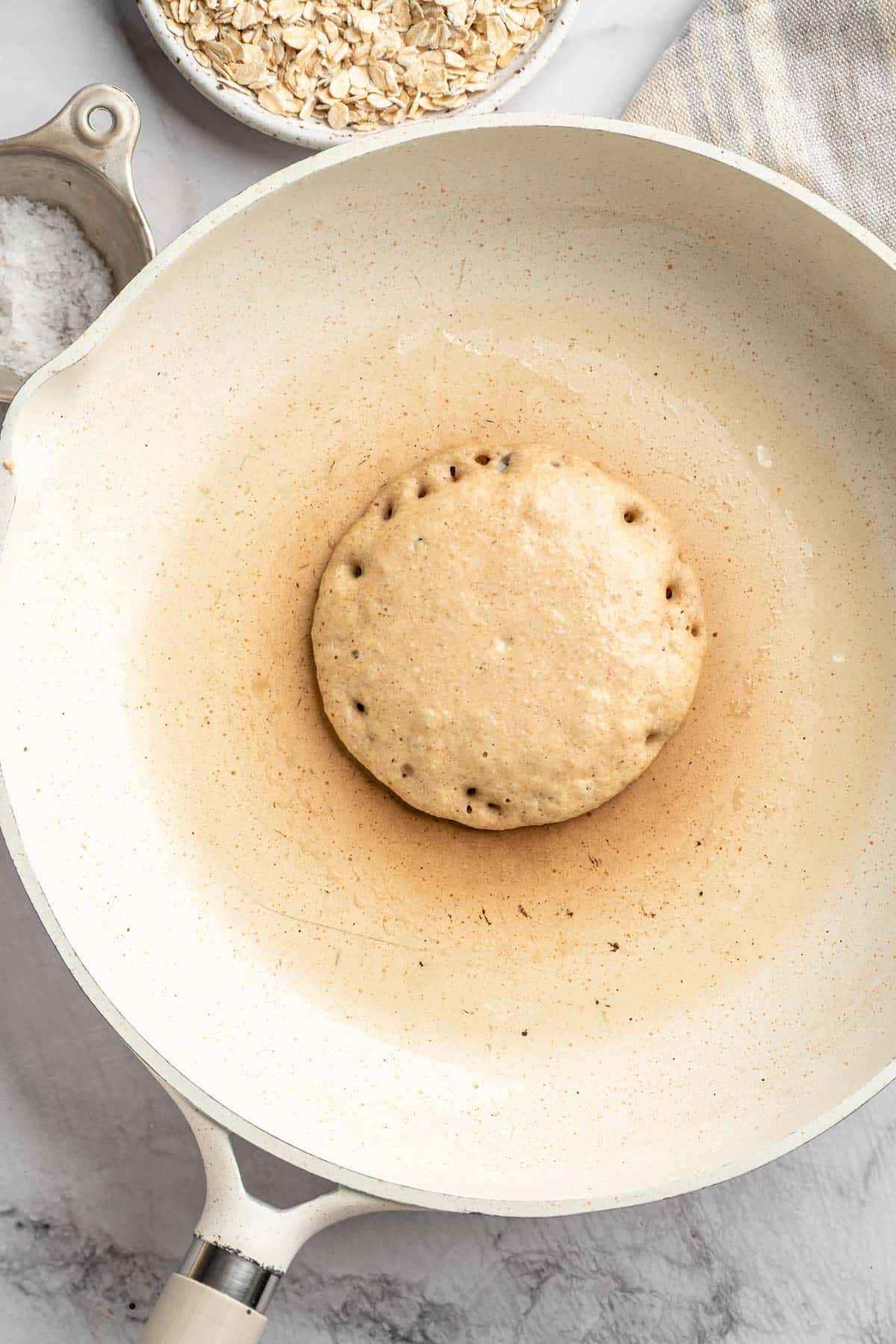 Pancake batter cooking in a large skillet.