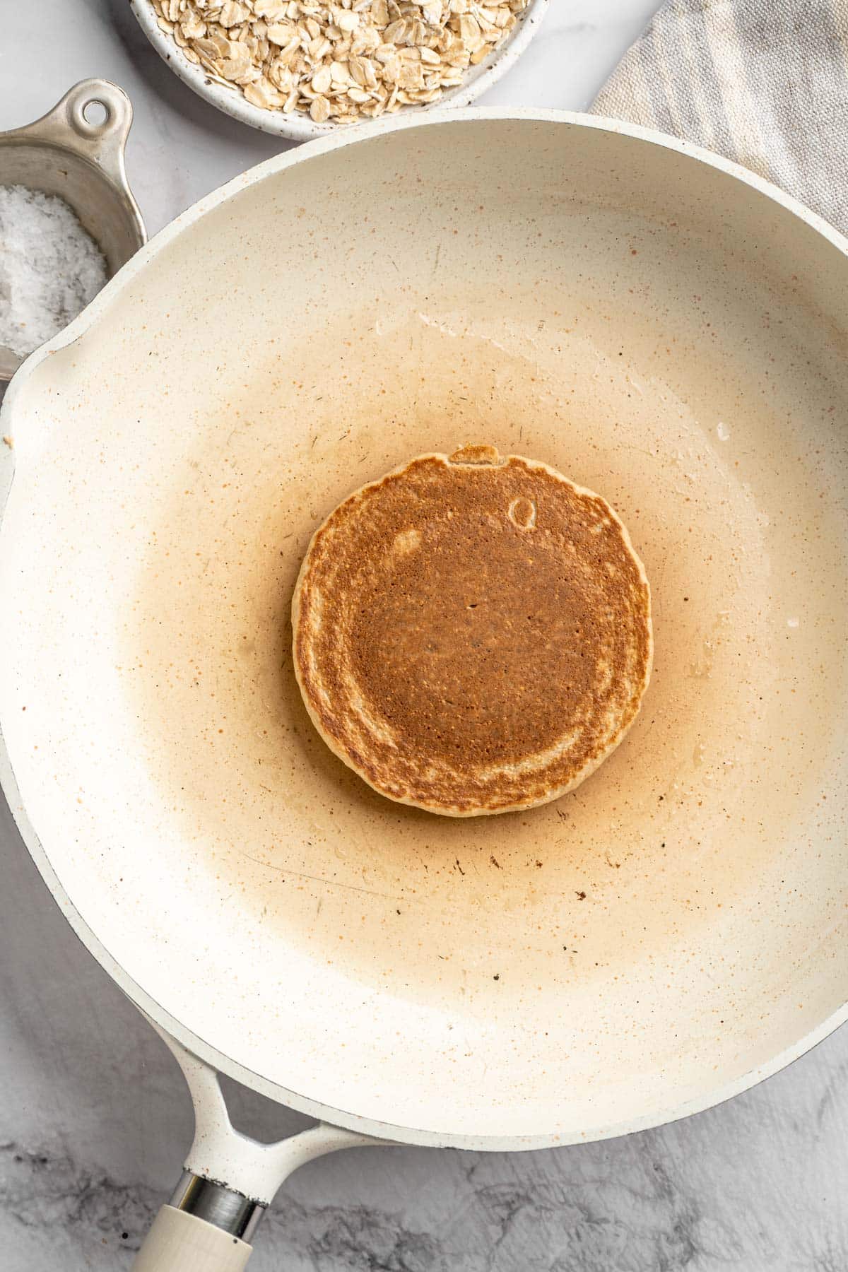 Pancake cooking on a skillet.