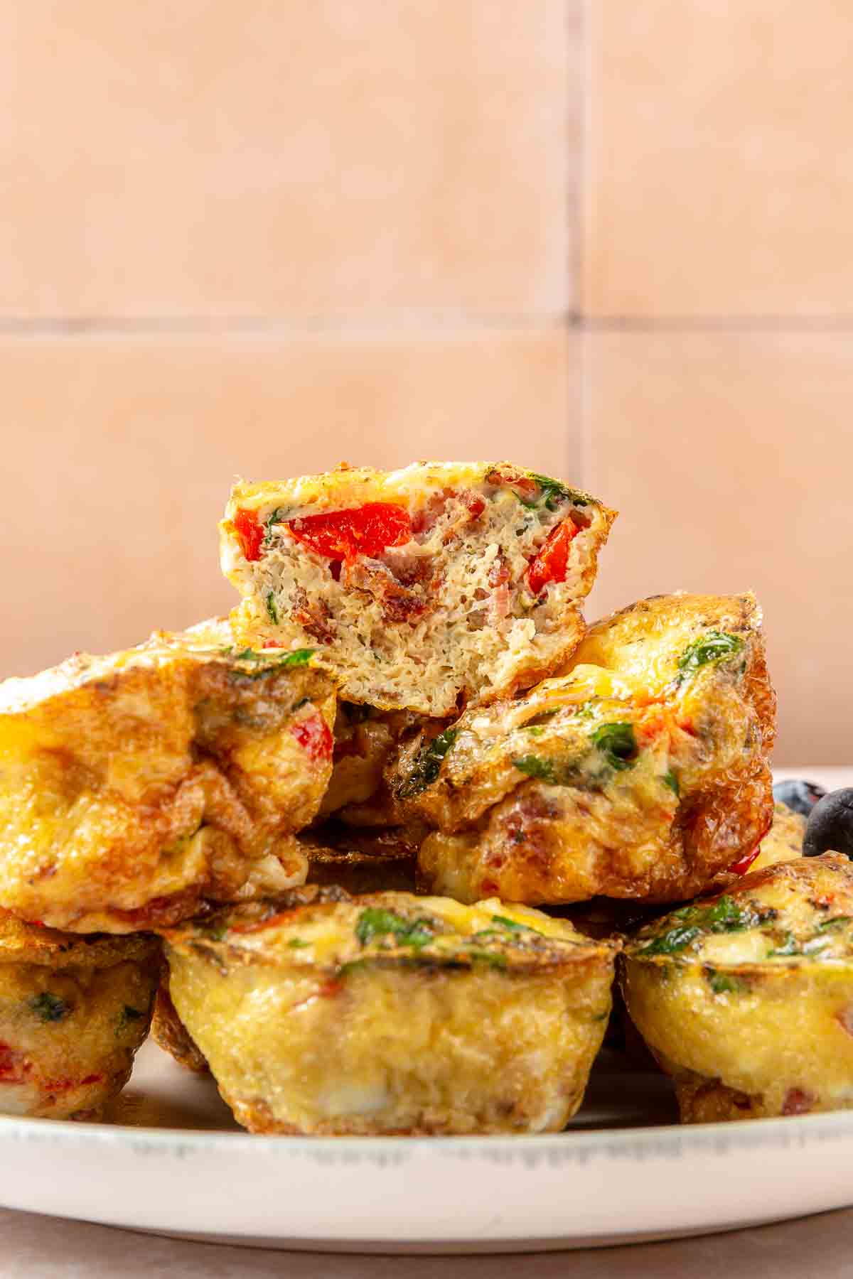 Egg muffin cups stacked on a white plate.