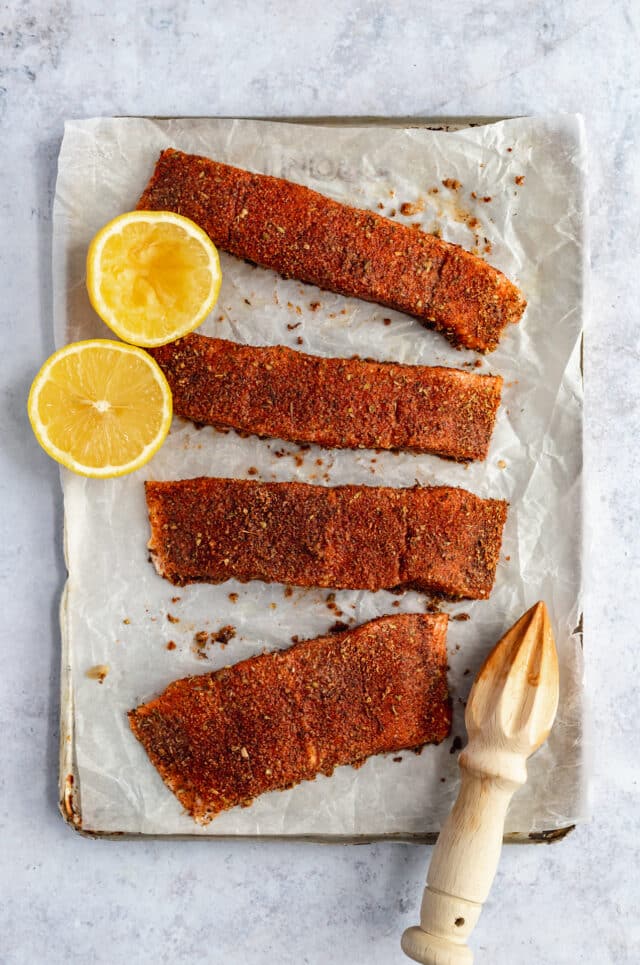 raw salmon on parchment paper with a rub 