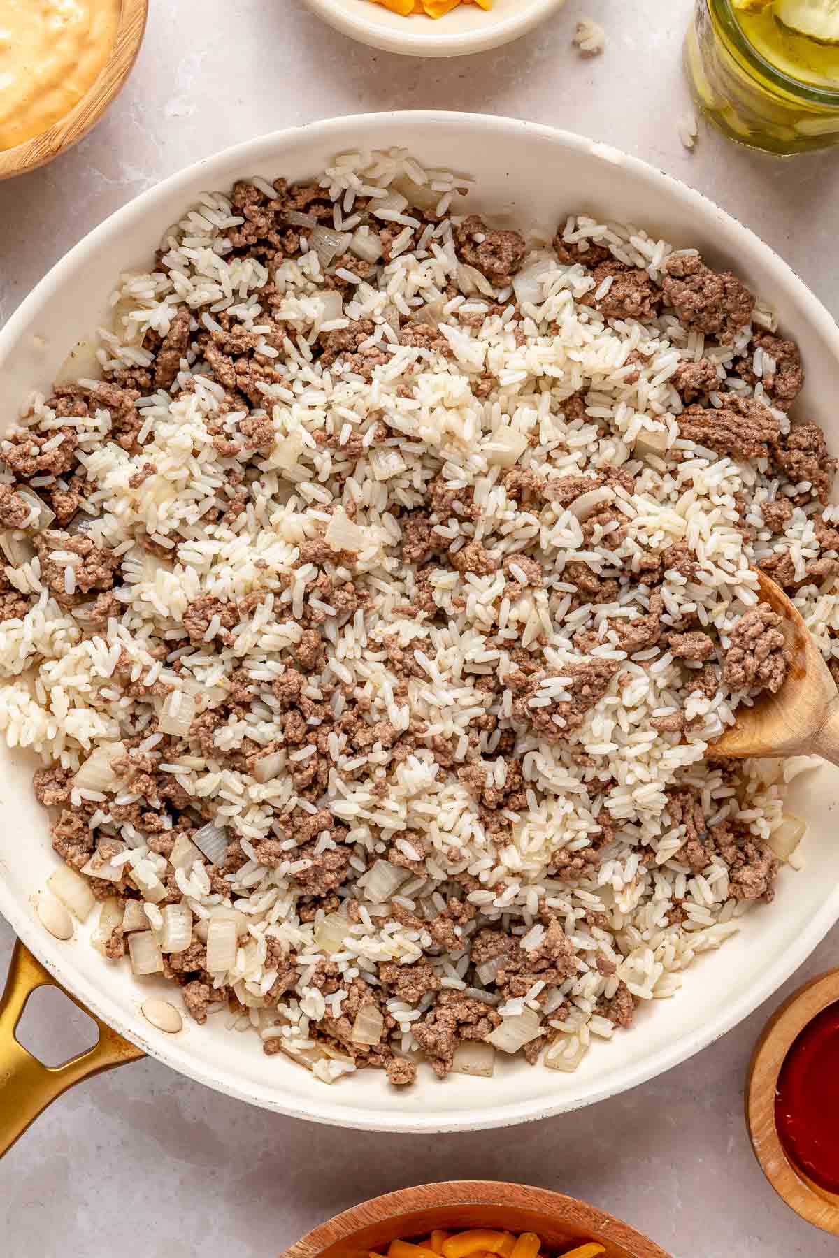 Browned ground beef in a skillet with rice.