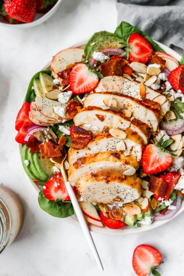 Spinach Strawberry Salad served in a white bowl with a gold fork