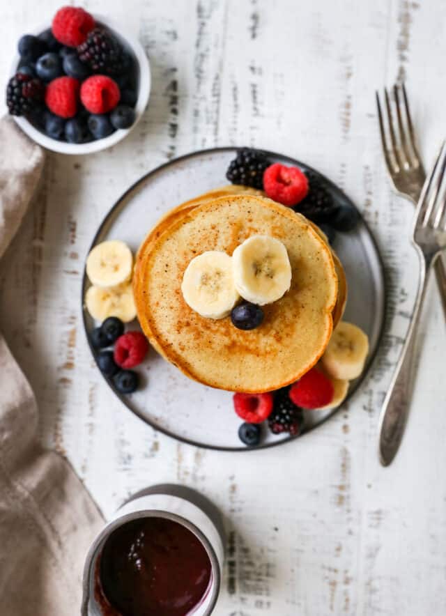 pancakes topped with banana slices and berries