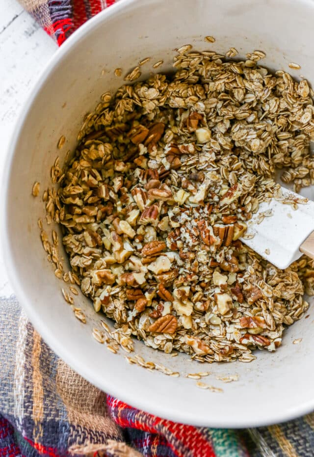 mixing oats, nuts and oil for granola recipe