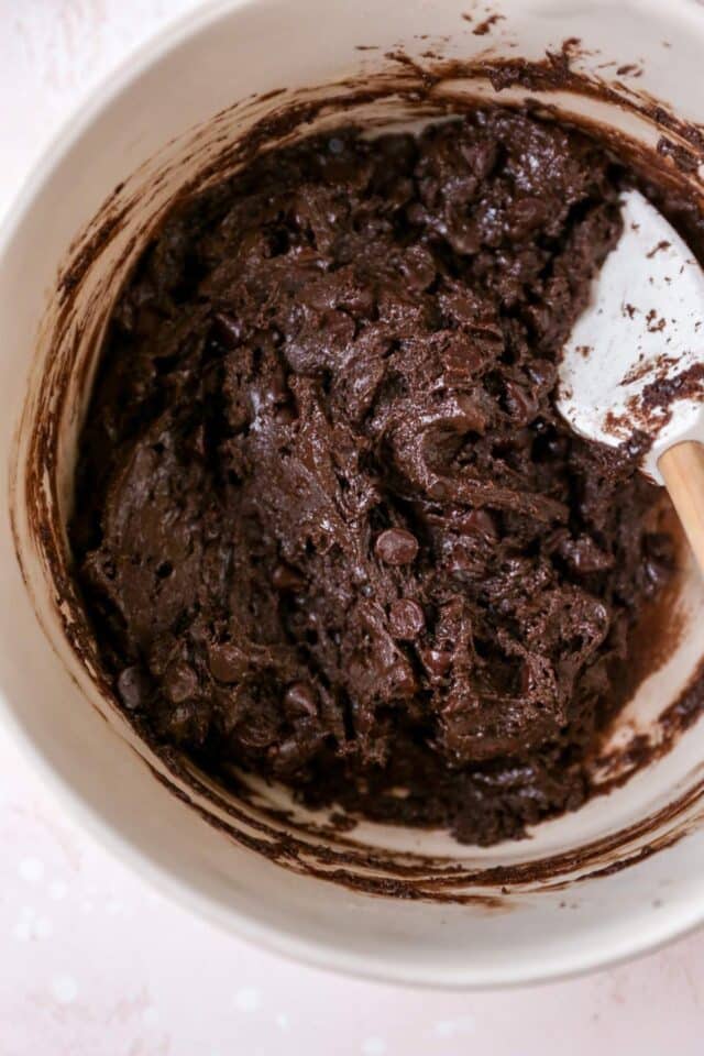 Stirring brownie batter in a large bowl.