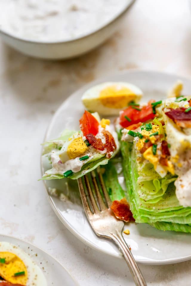 using a fork to take a bite of a wedge salad