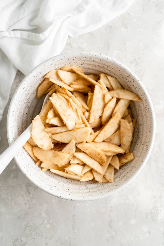 stirring apple slices with cinnamon and nutmeg