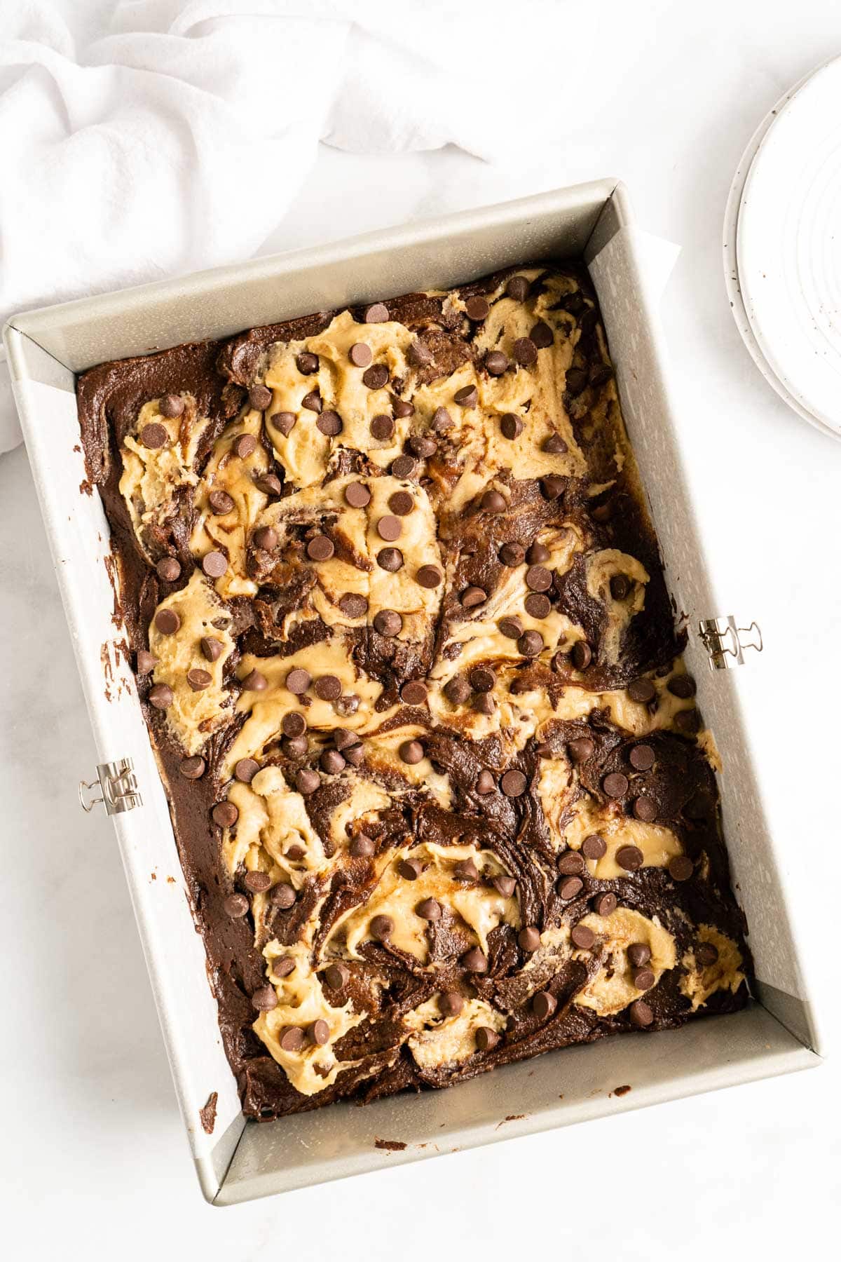 adding brownie batter and cookie dough to pan