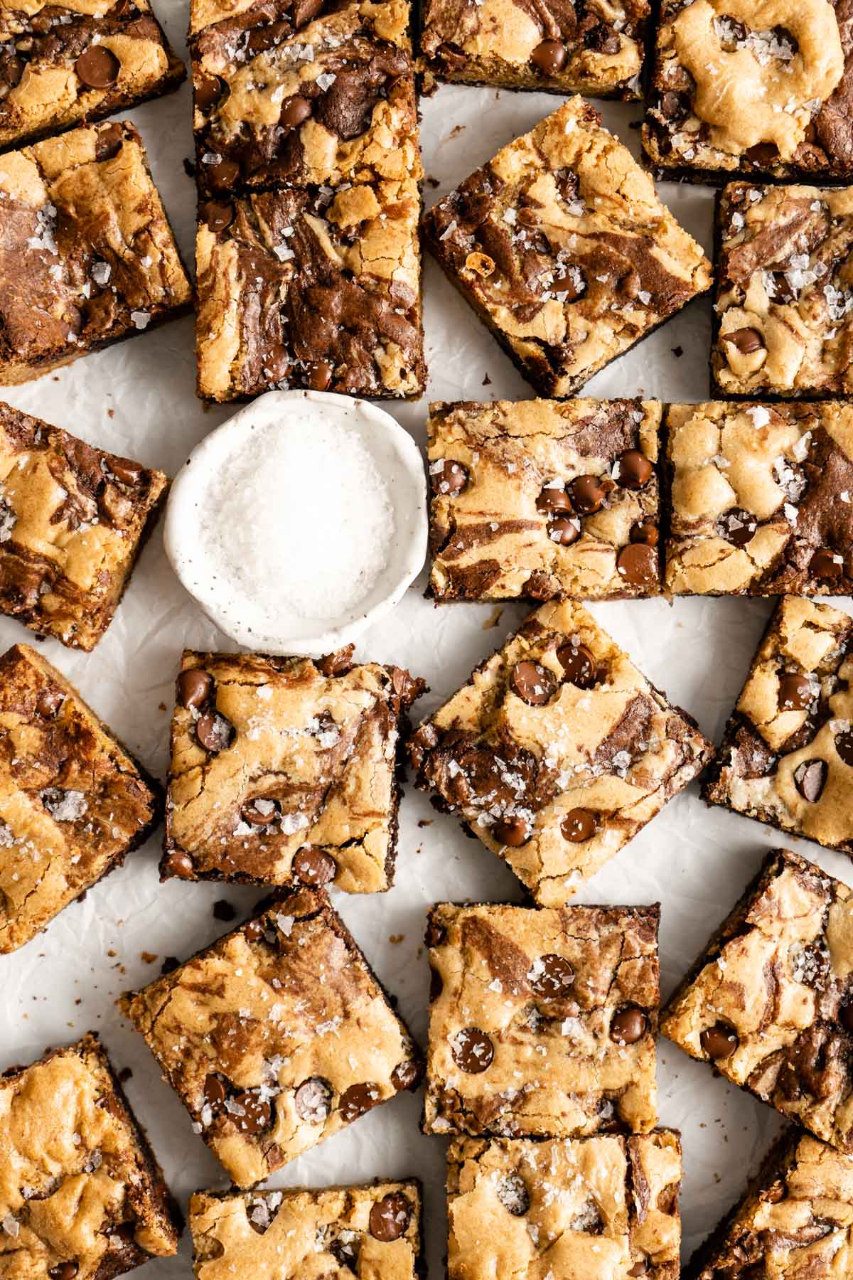 brookies topped with chocolate chips near a small bowl of sea salt