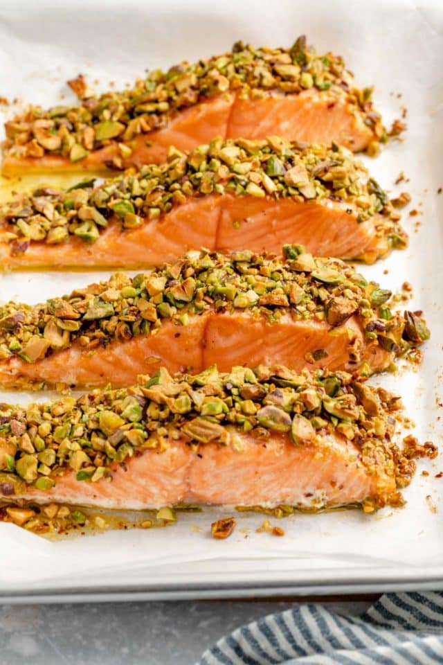 pistachio-crusted salmon on a parchment-lined baking sheet