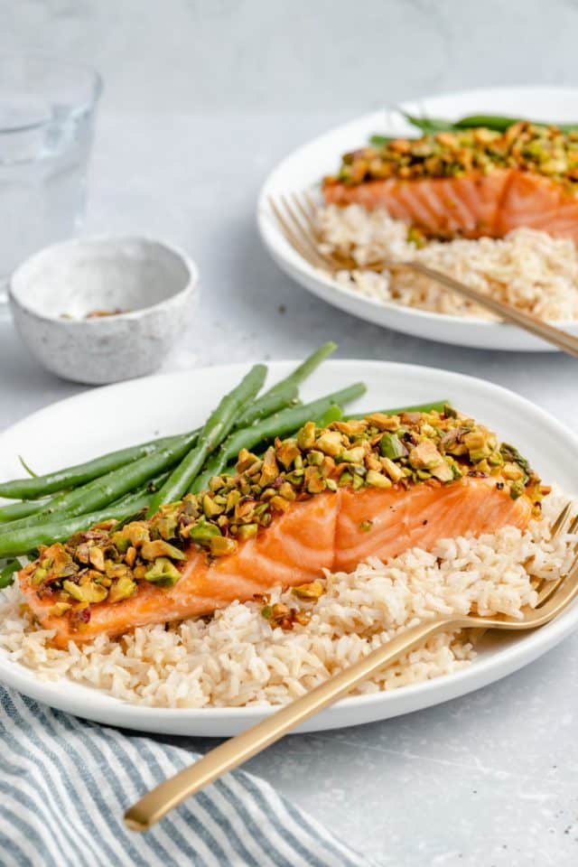 pistachio-crusted salmon on a plate with rice and green beans