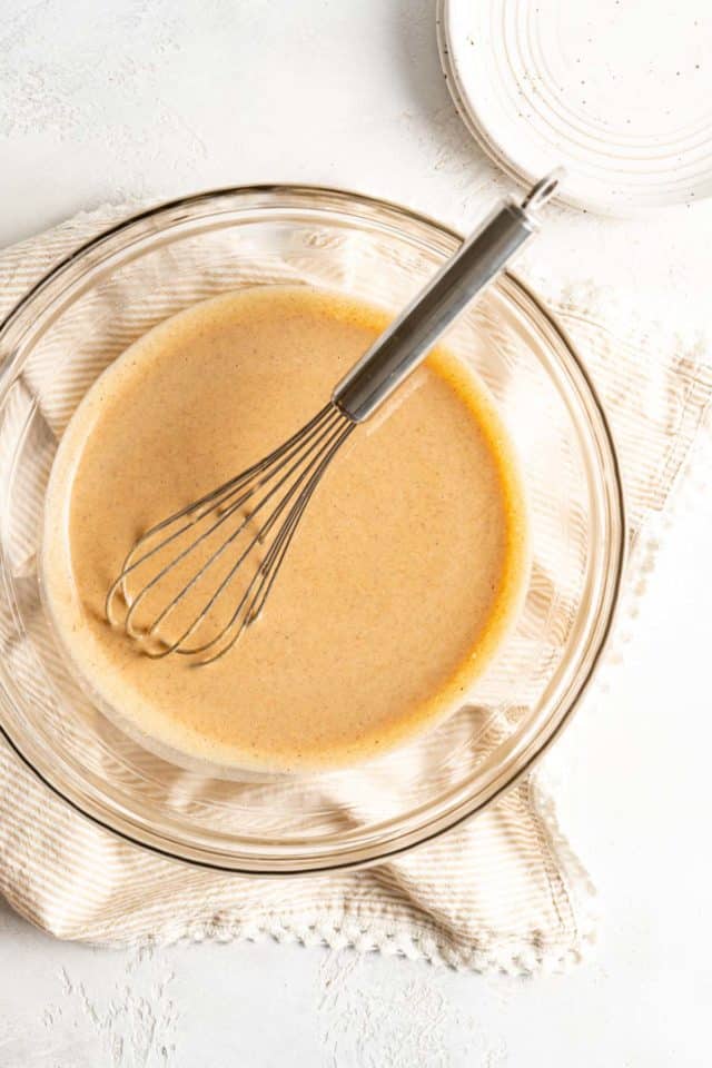 Whisking pumpkin puree with sweetened condensed milk and spices.