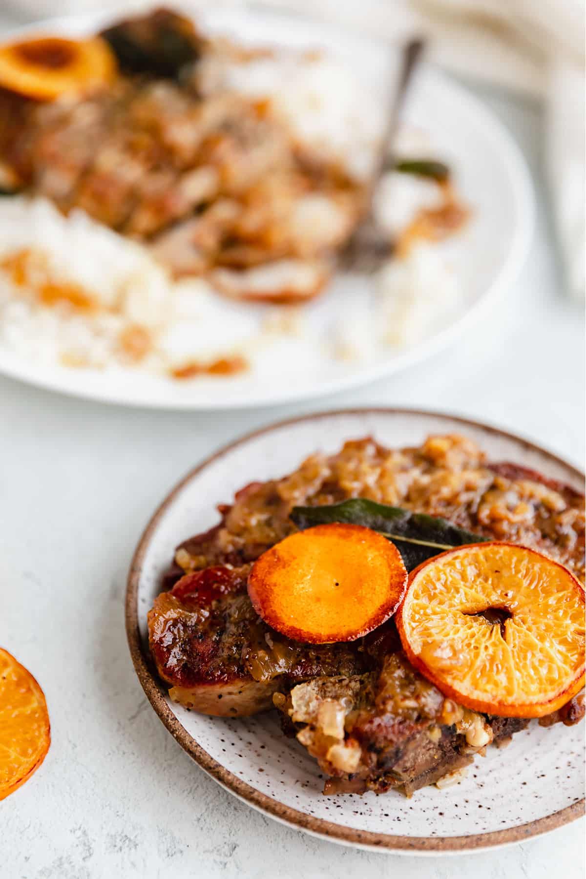 pork chops on a plate with an orange garnish