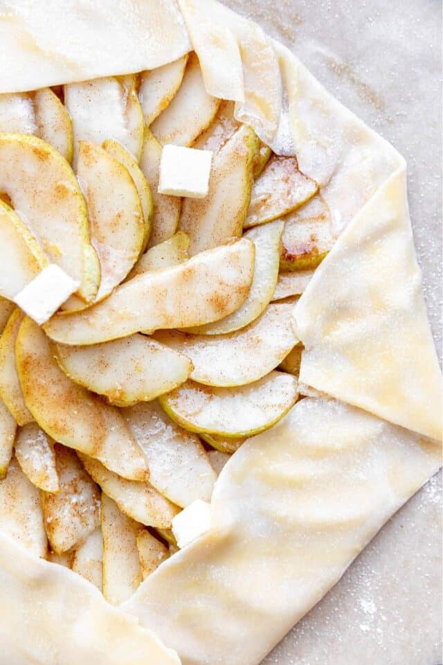 Butter dotted over a pear galette before baking.