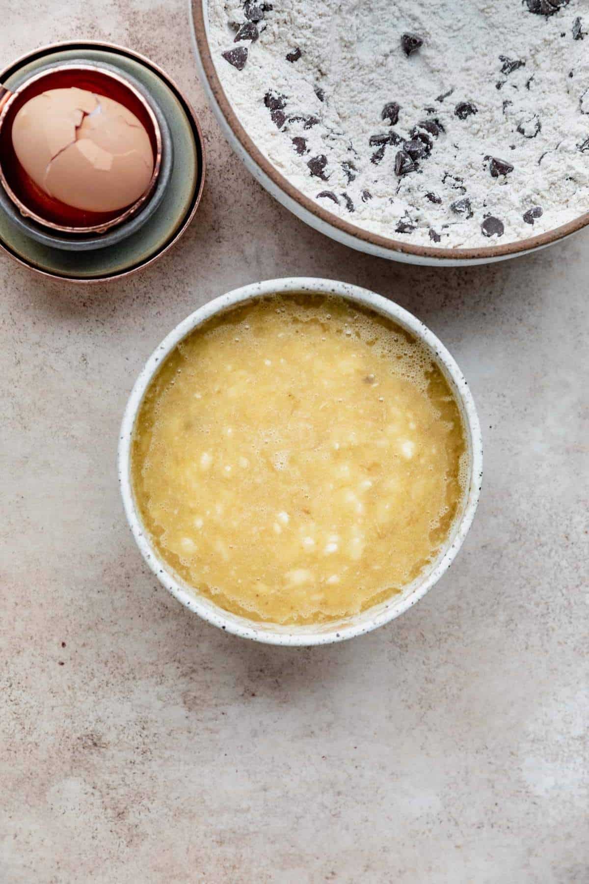 Mixing mashed bananas with eggs and oil.