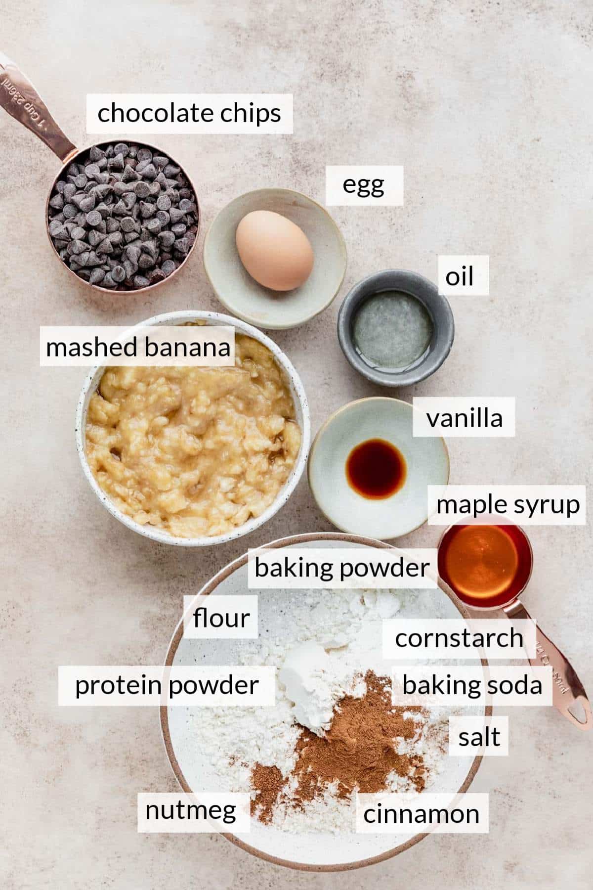 Small bowls with mashed banana, chocolate chips, egg, oil and maple syrup.