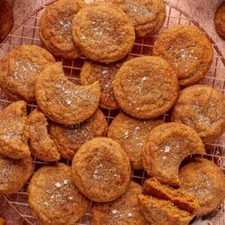 Cinnamon cookies on a wire rack near a glass of milk.