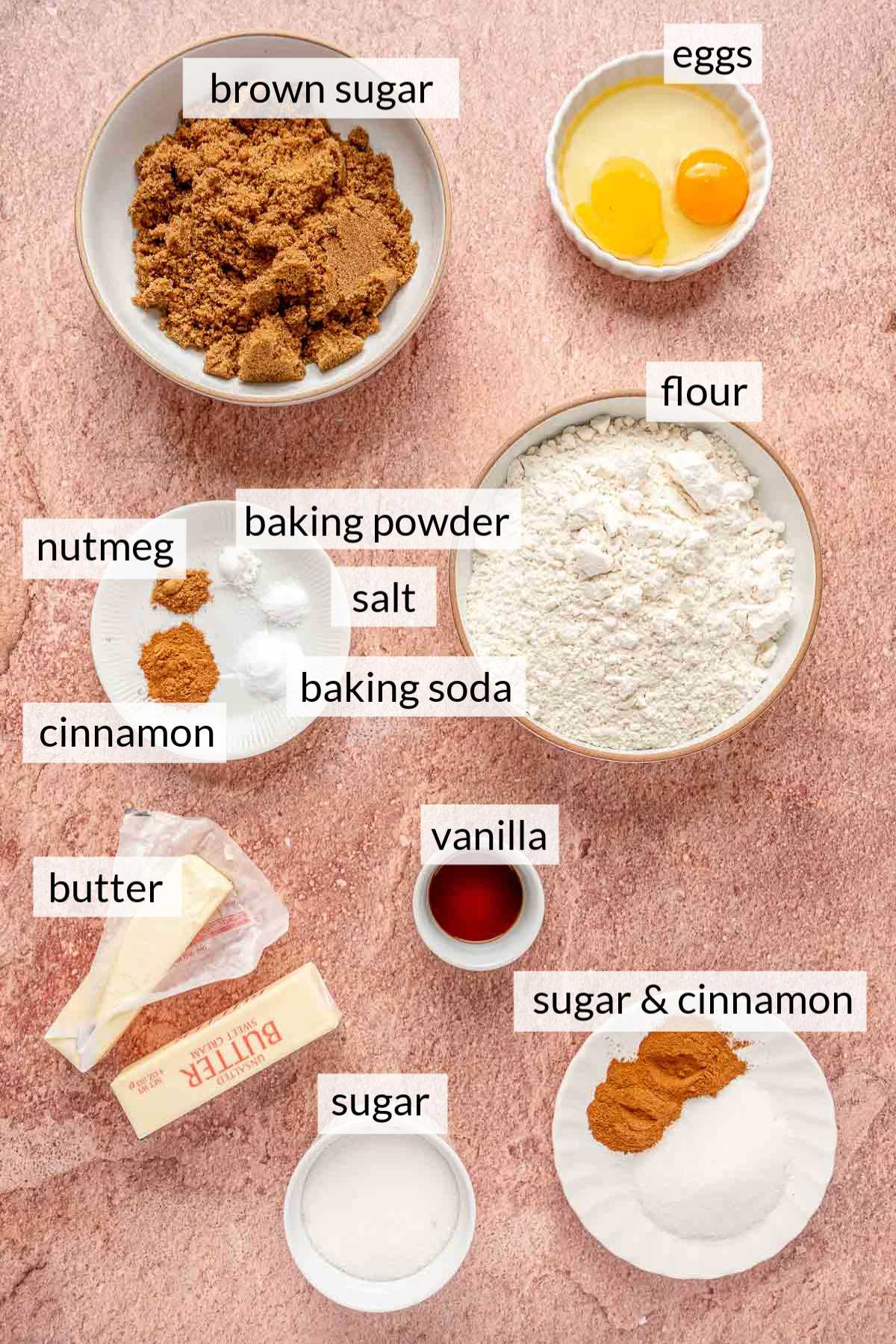 Bowls with flour, sugar, eggs, vanilla, and spices.