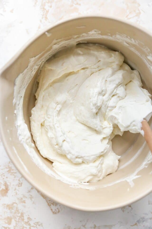 Folding heavy whipping cream into cream cheese mixture.