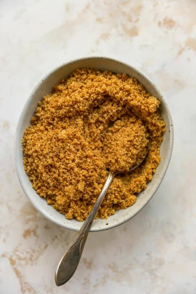 Stirring together graham cracker crumbs, butter and sugar in a small bowl.