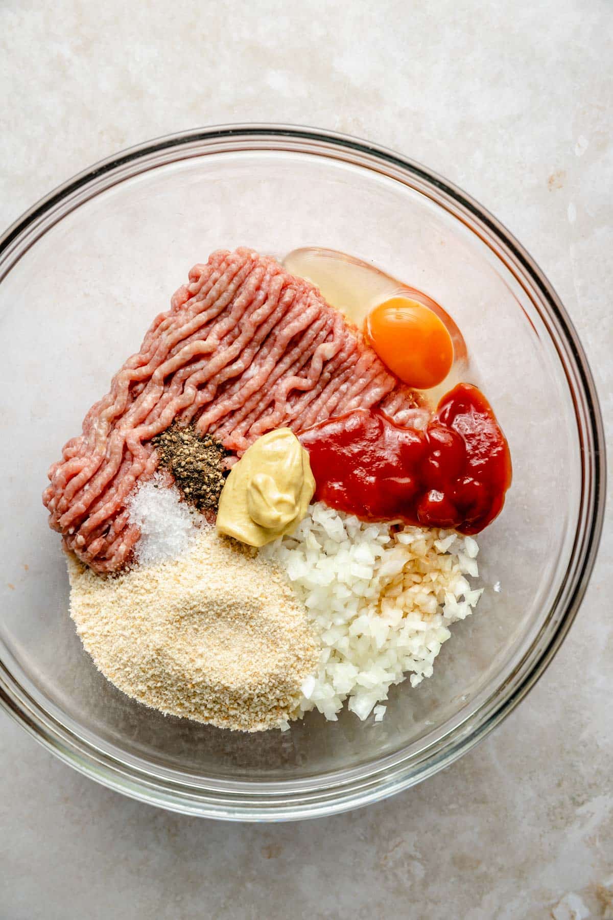 Mixing chicken burger ingredients in a large bowl.