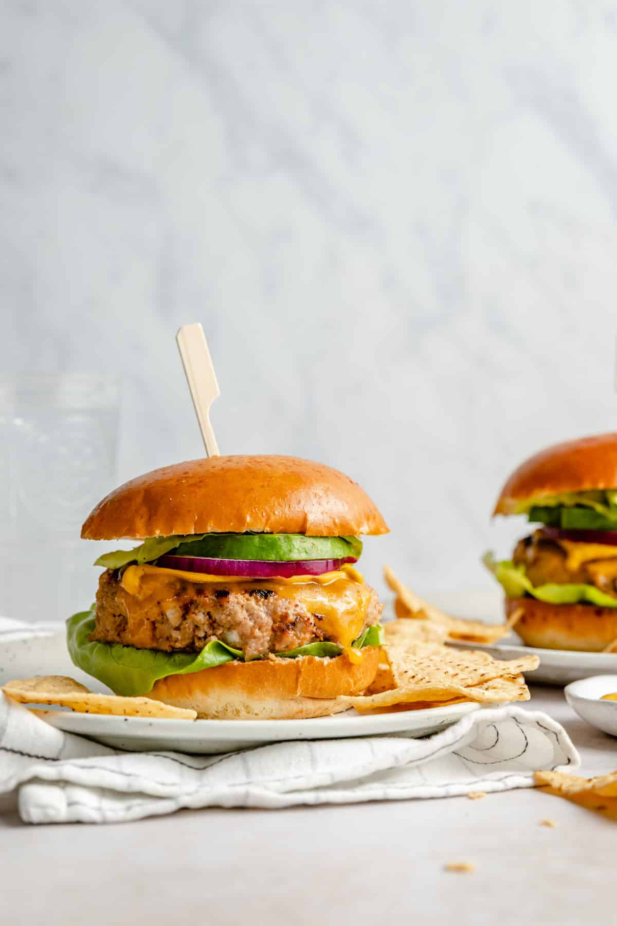 Burger served on a fluffy bun with chips.