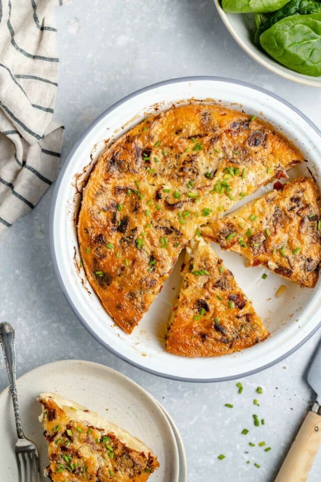 Sliced quiche in a pie plate.