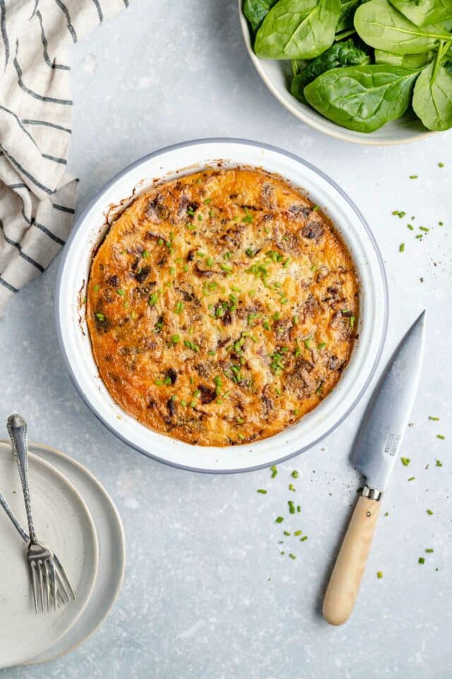 Baked quiche in a white pie dish.