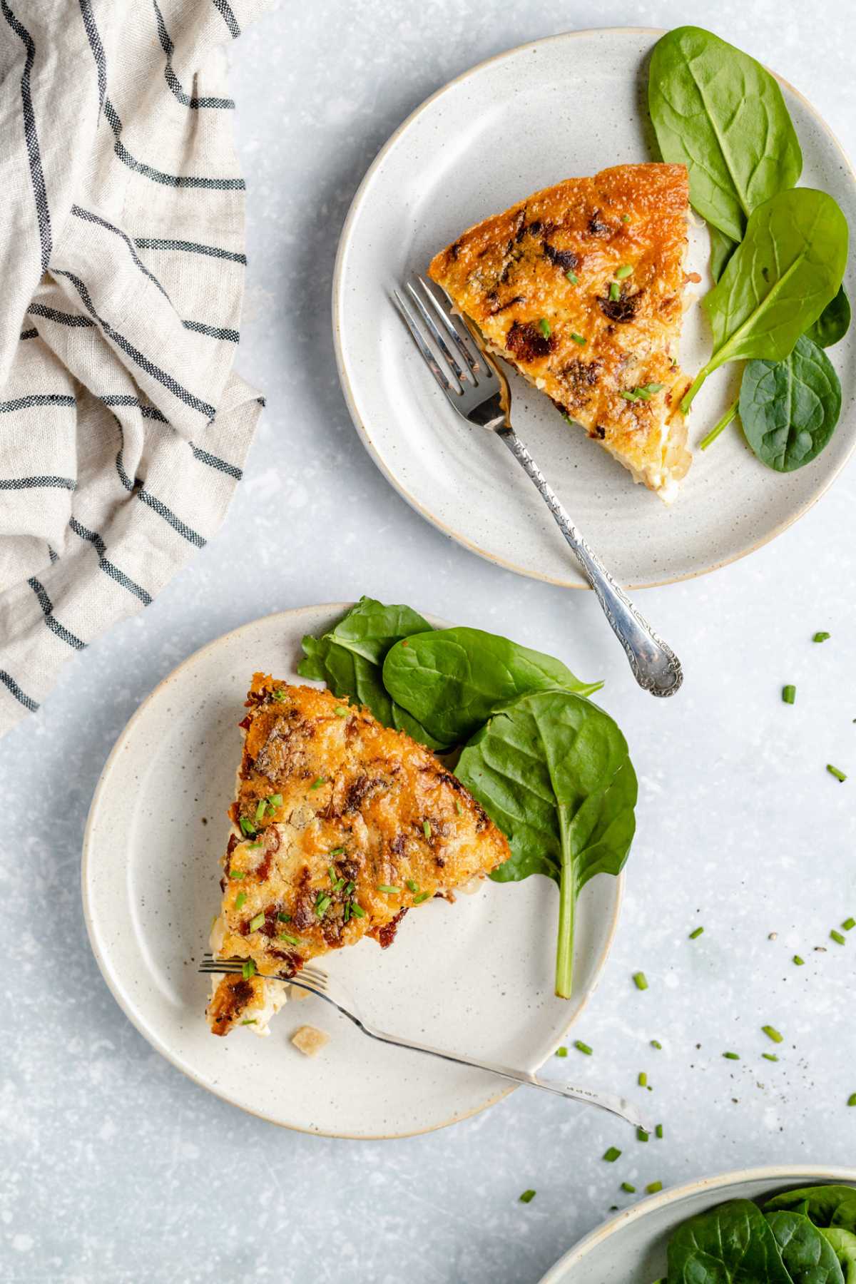 Slices of crustless quiche on white plates.