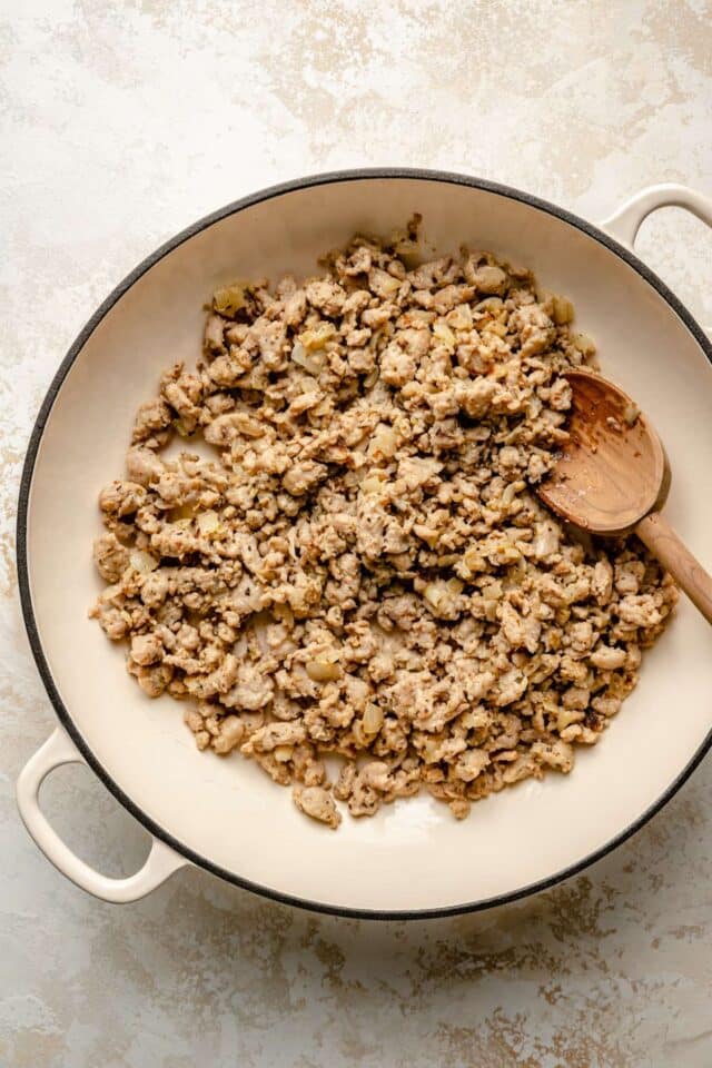 Cooking ground meat in a large pan.