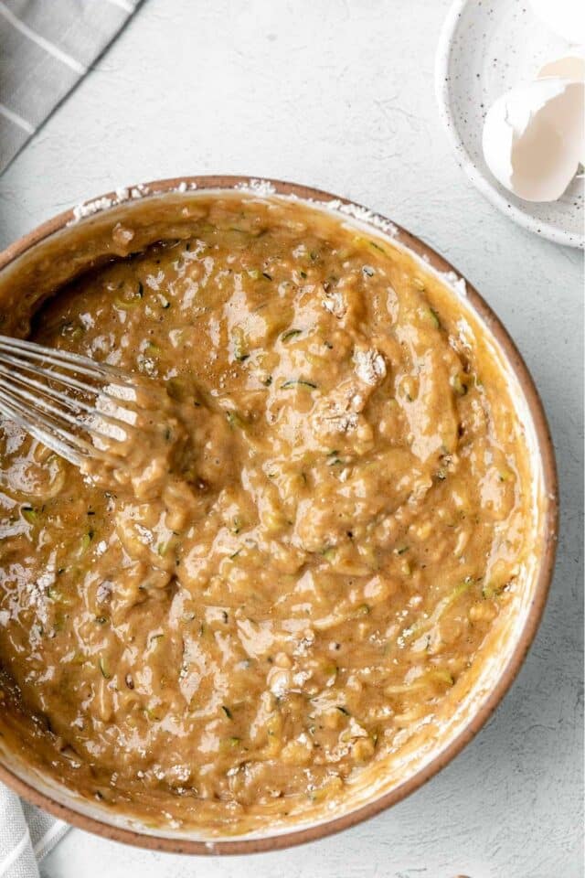 Mixing wet and dry ingredients together in a large bowl.