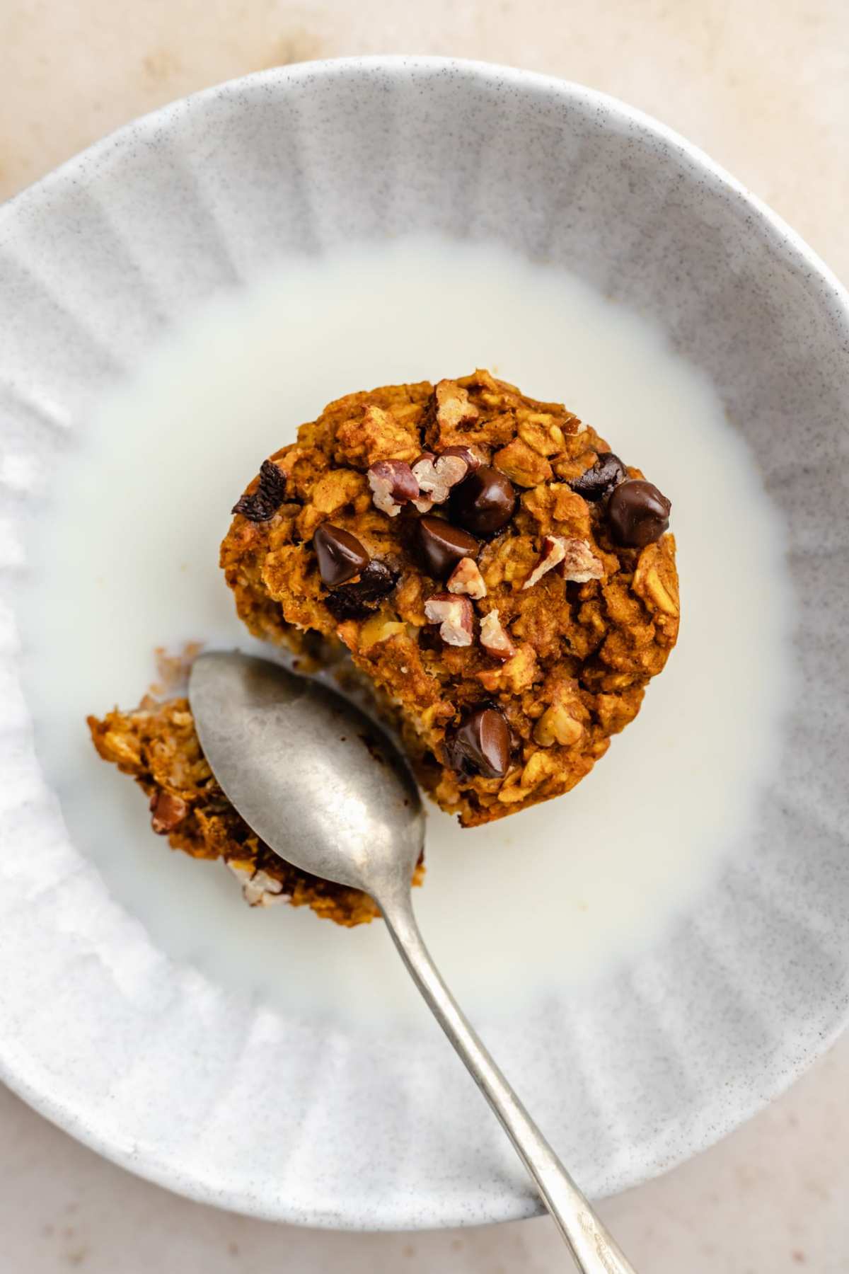 Chocolate chip pumpkin muffin served in a bowl with milk.