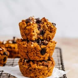 Pumpkin oatmeal muffins stacked on a wire rack.