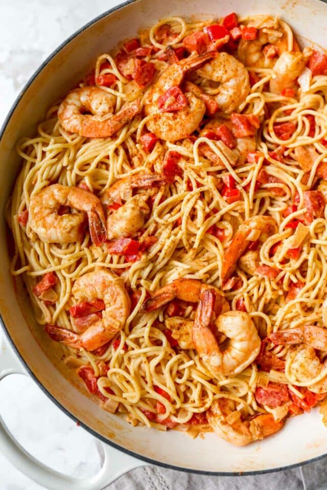 Shrimp and pasta in a pan with a creamy tomato sauce.