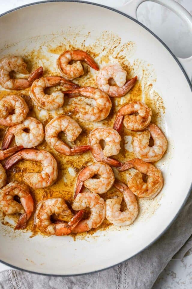 Shrimp cooking in a large skillet.