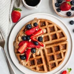 Banana oat waffle topped with berries and almond butter.