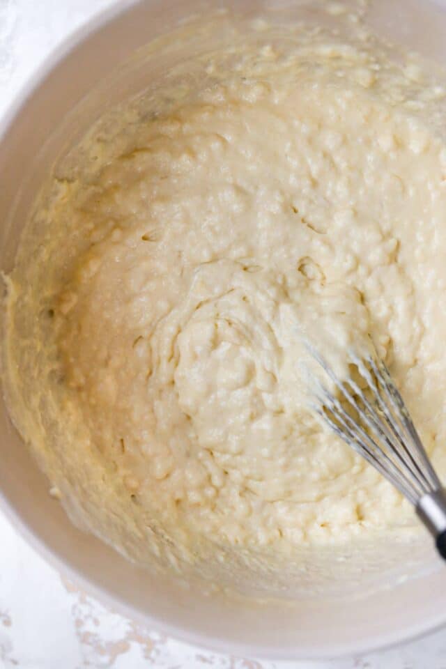 Whisking waffle mix in a large bowl.