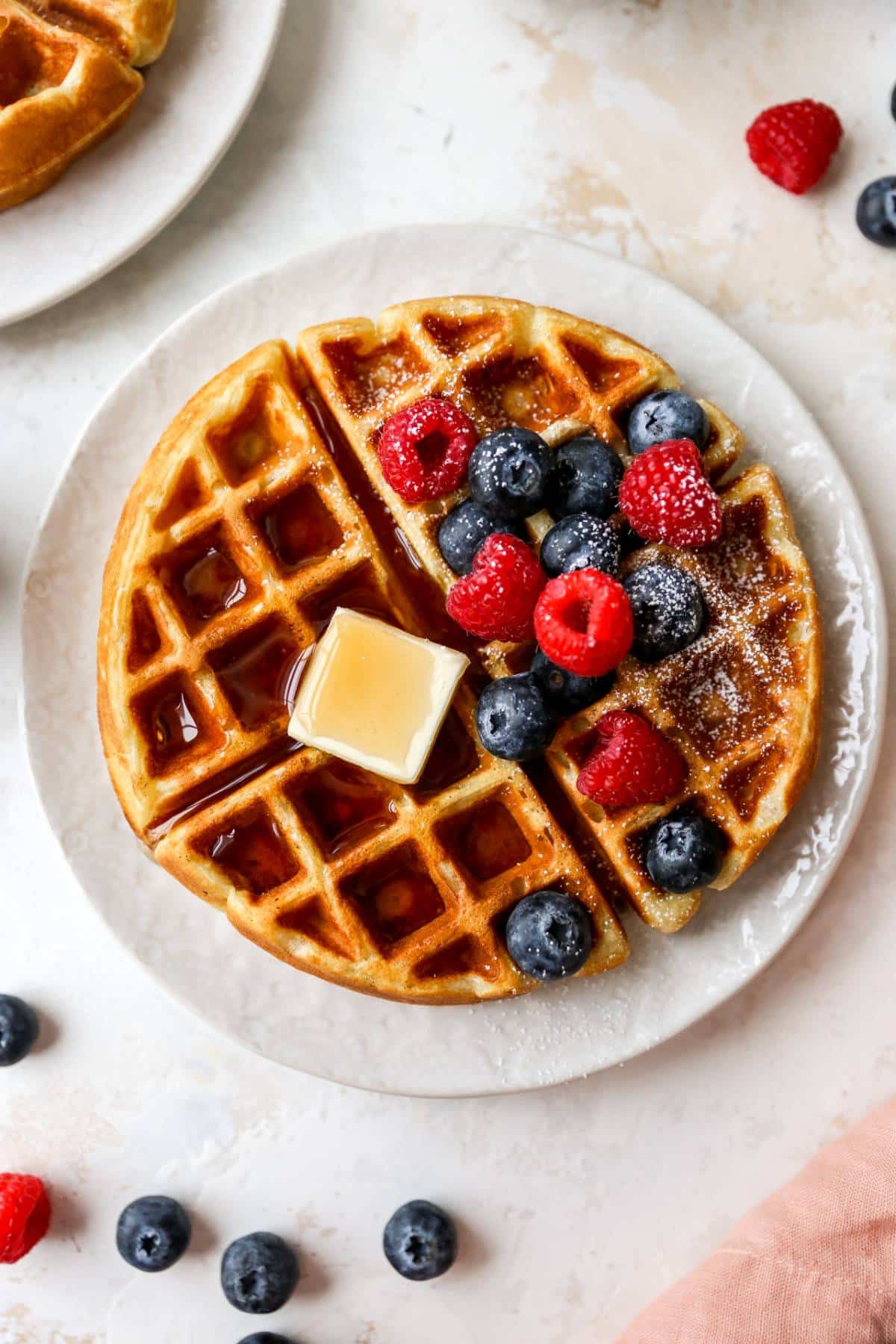 Buttermilk waffles topped with butter, maple syrup and fresh berries.